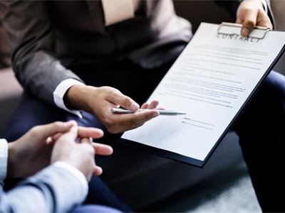 Pessoa com contrato na mão pedindo assinatura