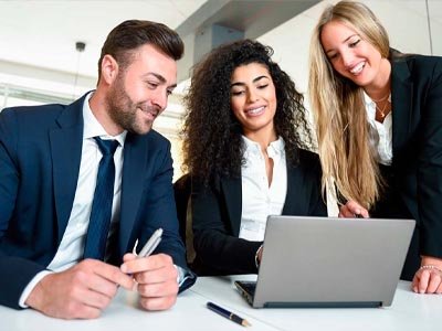 Pessoas numa mesa discutindo assunto que está num computador