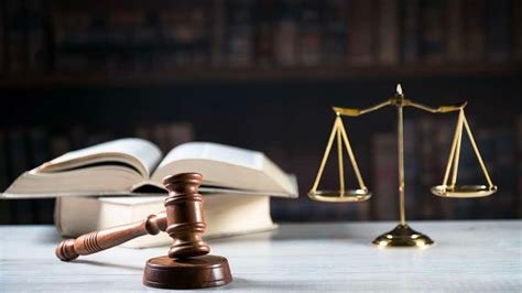 Martelo de juiz com livros e uma balança em equilíbrio.